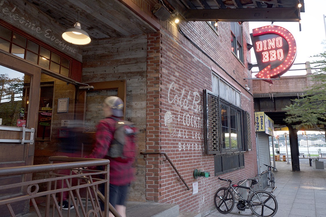 A person in motion enters a brick building