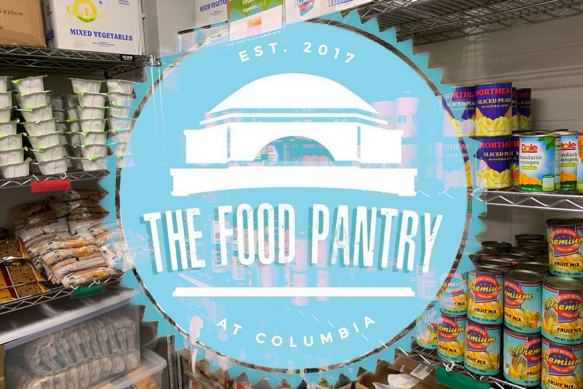 A photo of a food pantry with a light blue seal that says The Food Pantry at Columbia, established in 2017