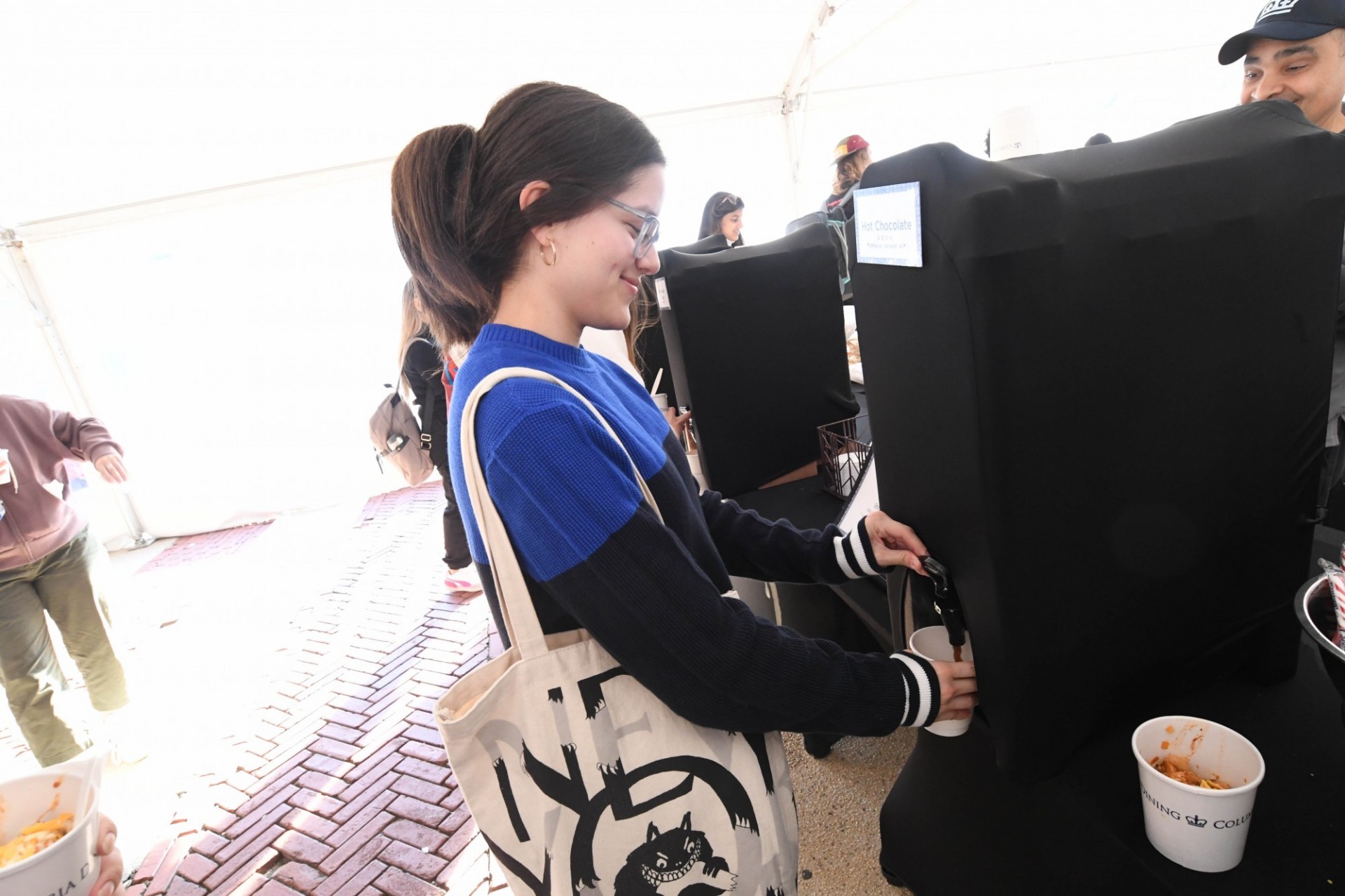 A student getting hot chocolate from a dispenser