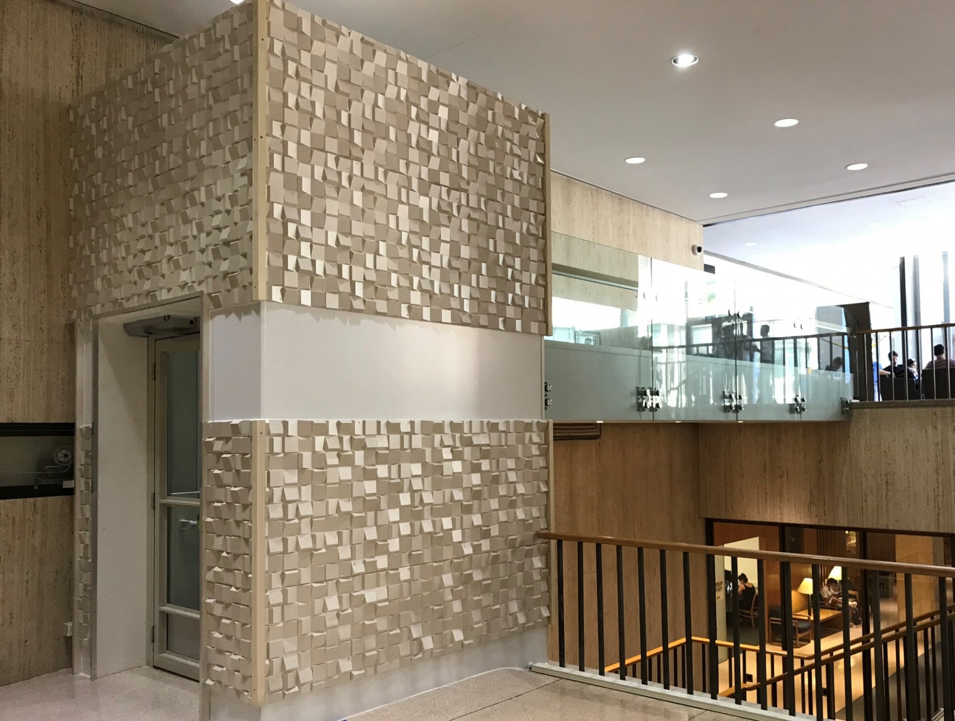 The accessible lift on the fourth floor of the International Affairs building, which has tan tiles to blend in with the adjacent wall.