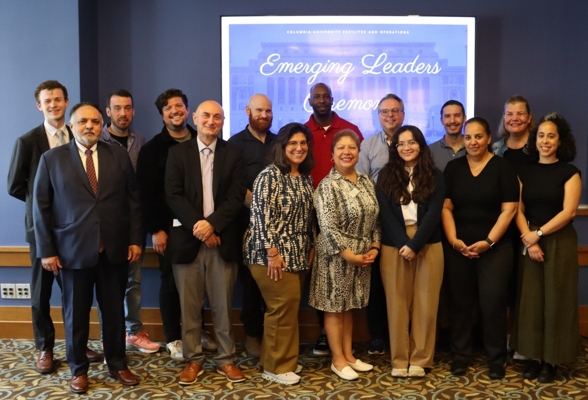 A group of people standing in front of a sign that reads "Emerging Leaders Ceremony."