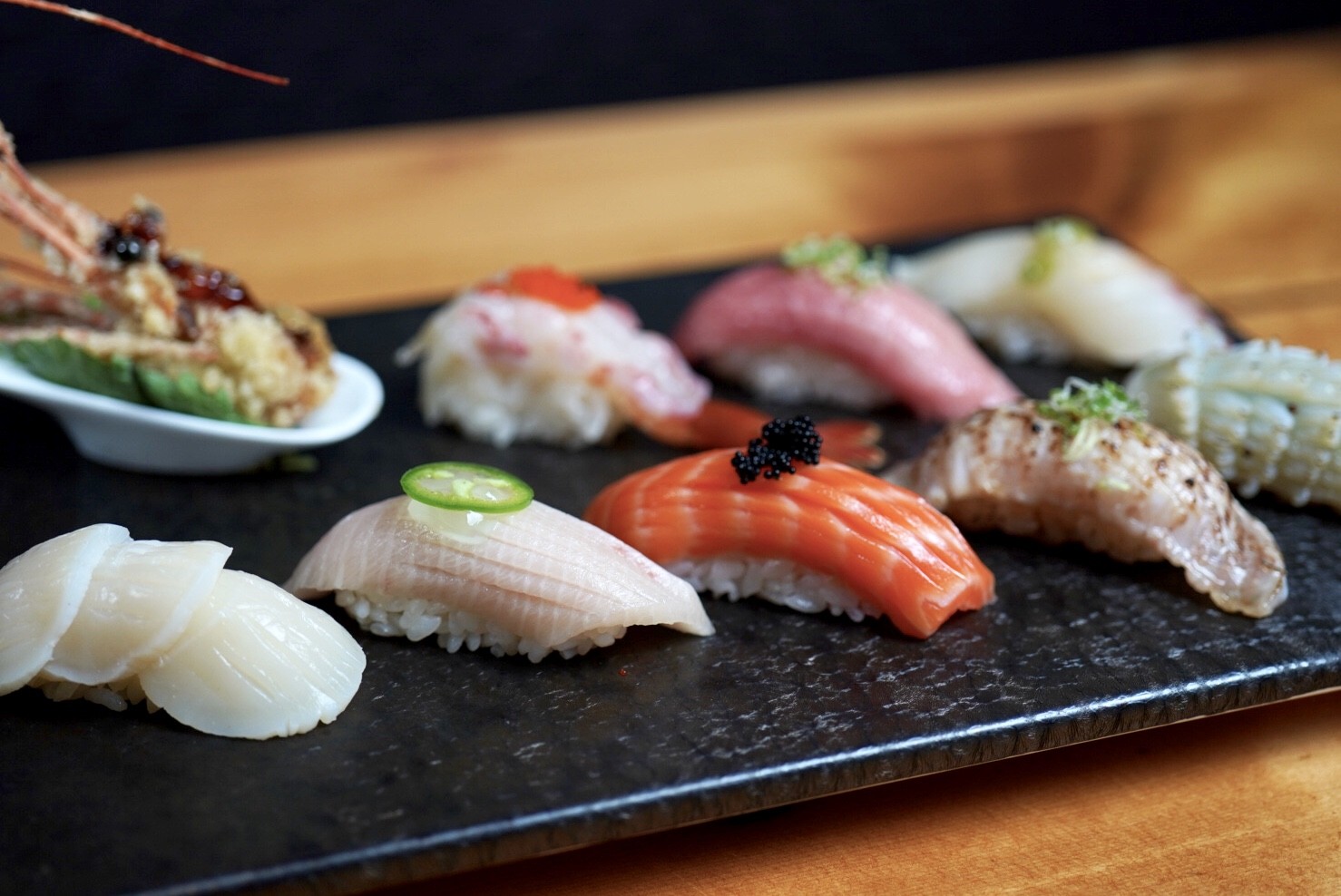 A close up shot of a plate of assorted sushi.  