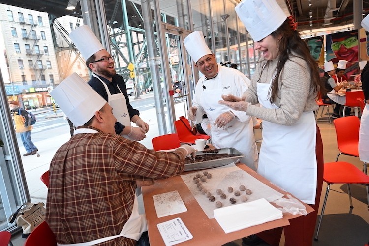 Photo: Diane Bondareff Chef Mike helps people wearing aprons and chef hats make truffles.