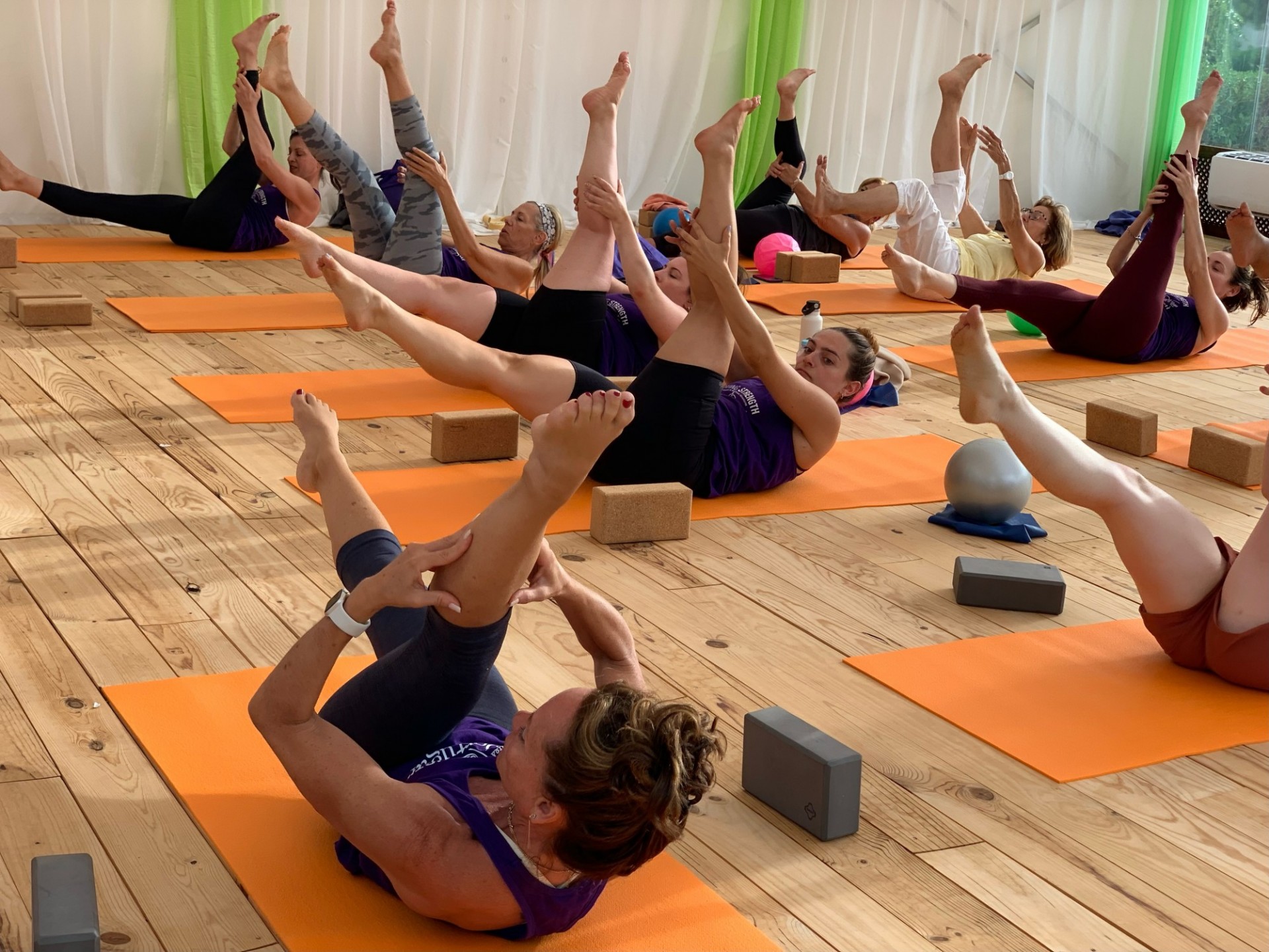 A pilates class doing poses on their mats.