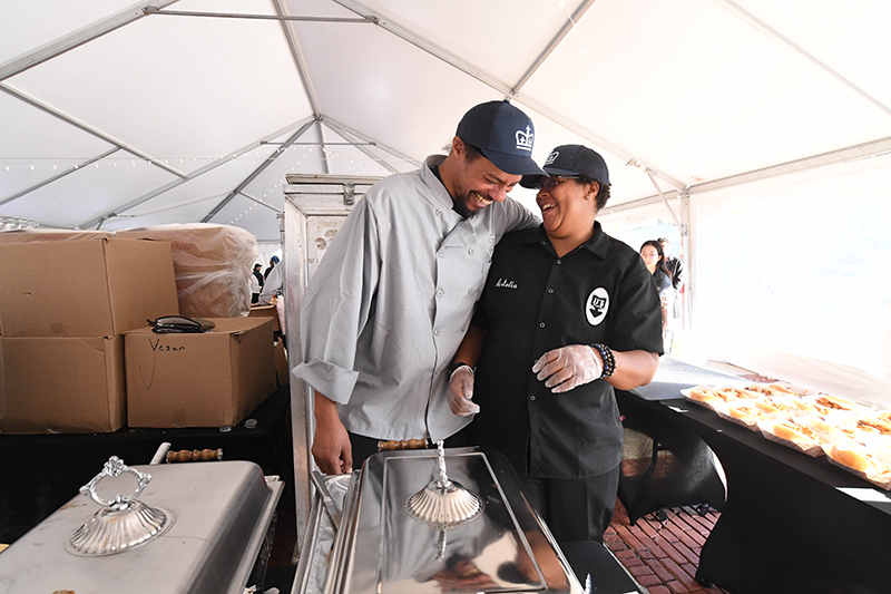 Two staff laughing at a joke inside the event tent