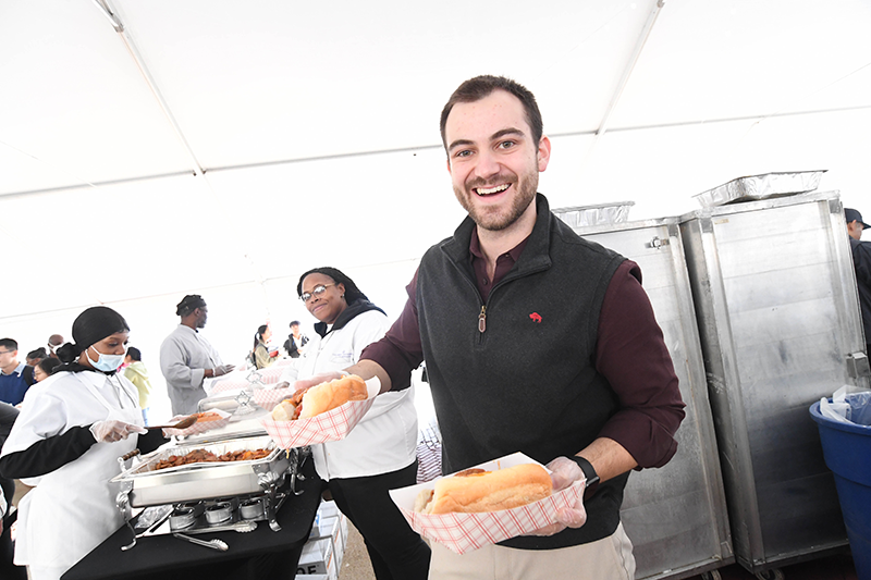 Service with a smile from Ian, one of our managers at Ferris A staff member holds plates of sausages in rolls with peppers