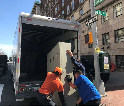 Columbia University Donates Lockers to Local Boarding School for Boys three Facilities employees loading used lockers into white truck